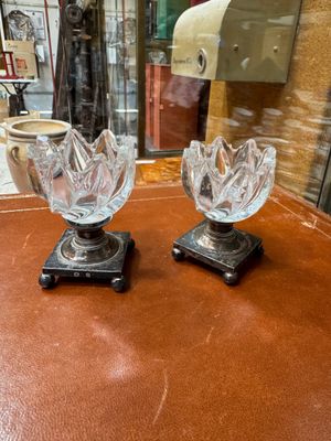 two glass vases sitting on a table in front of a window