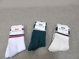 three pairs of white and green socks sitting on top of a couch