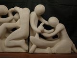 sculpture of a couple hugging each other on a wooden shelf