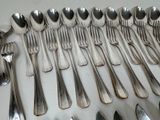 a lot of silver spoons and spoons on the table