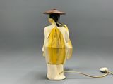 a statue of a woman with a hat and yellow dress