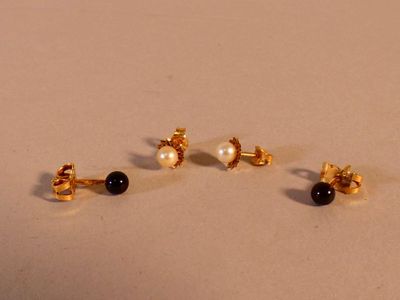 trois paires de boucles d'oreilles à clous en perles noires et blanches posées sur un fond blanc