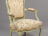 an antique chair with a floral upholstered back and arms