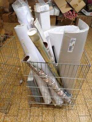 many rolls of paper in a wire basket on the floor