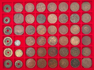 un assortiment de pièces d'argent et de bronze présenté dans un présentoir rouge