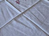 a white towel with red letters on it on a bed