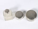 two small silver containers with silver lids on a white surface