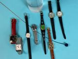 many different types of watches on a blue table