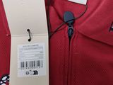 a close up of a red polo shirt with a tag on it