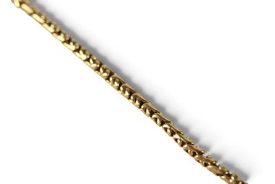gros plan d'un bracelet en or sur fond blanc