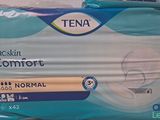two packs of tena baby diapers sitting on top of each other