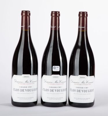trois bouteilles de vin rouge posées sur une table blanche