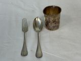 a spoon, fork and a cup on a table