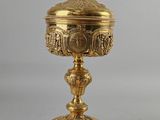 une coupe plaquée or surmontée d'une croix