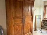 une grande armoire en bois dans le coin d'une pièce