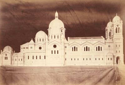 une vieille photo d'un très grand bâtiment sur lequel figure une horloge