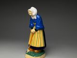 an old figurine of a woman with a blue dress and yellow skirt