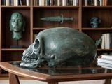 a skull sitting on a table in front of a bookshelf