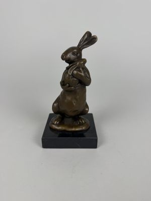 a bronze statue of a rabbit sitting on top of a black base