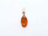 un pendentif en or jaune orné d'une pierre d'ambre de forme ovale