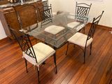 une table en verre avec quatre chaises et un meuble en arrière-plan