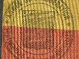 a close up of a yellow and red bag with a stamp on it