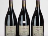 trois bouteilles de vin posées les unes à côté des autres sur une surface blanche