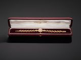 an image of a gold bracelet in a red box on a black surface