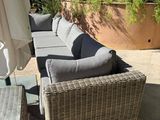 two couches and a table on a patio with an umbrella
