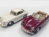 two toy cars sitting next to each other on a white surface