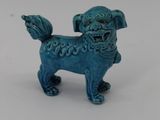 blue ceramic dog figurine on white surface with white background