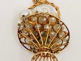 an image of a gold plated pendant with pearls and a shell