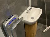 a small bathroom with a toilet, sink, and shower