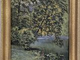 une peinture à l'huile représentant un arbre au bord d'un lac, dans un cadre doré