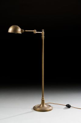 an antique brass floor lamp with a black background