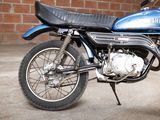 a blue motorcycle that is parked in front of a brick wall