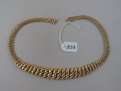 a close up of a gold chain bracelet on a white surface
