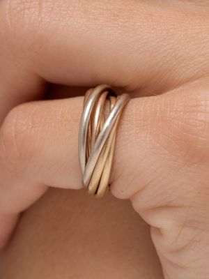 quelqu'un tient dans sa main une bague en or et en argent
