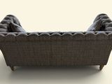 an image of a gray couch with a buttoned back and arms