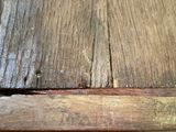 a close up of a wooden table with a piece of wood sticking out of it