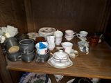 many cups and saucers sitting on a wooden shelf
