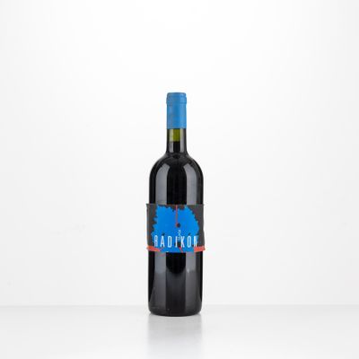 the bottle of red wine is sitting on a white table