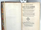 un livre ouvert sur une table, sur lequel est posé un étiquette