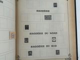 an open book with stamps on it on a white surface