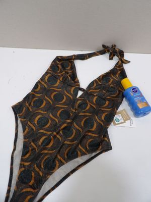 bathing suit and sunscreen lotion sitting on a white surface
