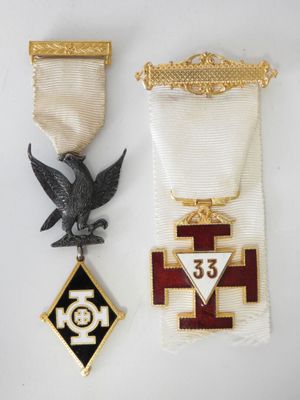 a close up of two medals on a white surface
