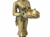 brass figurine of a woman holding a tray of food