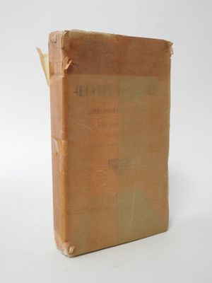 an old book sitting on top of a white table next to a white wall