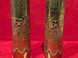 Deux vases sont posés sur une surface rouge, avec un fond rouge.