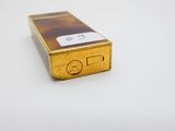 un petit téléphone portable doré posé sur une surface blanche
